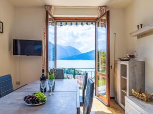 a dining room with a view of the water and mountains at Apartment Elena by Interhome in Bellano