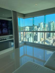 a living room with a view of a city skyline at Terra Brasilis Linda vista mar, completo, aconchegante, bem localizado in Balneário Camboriú