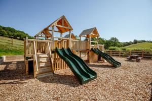een houten speeltuin met een glijbaan en een prieel bij Carters Cottage - Rudge Farm Cottages in Bridport