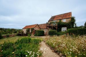 een oud huis met een tuin ervoor bij Carters Cottage - Rudge Farm Cottages in Bridport