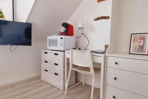 una cucina con scrivania, forno a microonde e computer di l'Ecrin de l'Aa - La Salicorne a Grand-Fort-Philippe