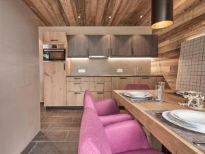 een keuken met roze stoelen en een houten tafel bij Holiday Home Bergsteiger - Chalet by Interhome in Sölden