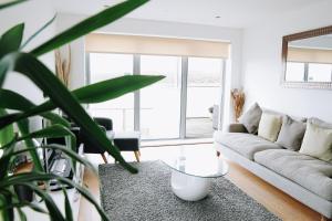 una sala de estar con un sofá y una mesa en Azure 7 Apartment, en Newquay 5 fotos más