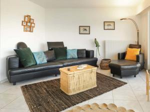 a living room with a black leather couch and a table at Villa Route de la Muraz 9 by Interhome in Villeneuve