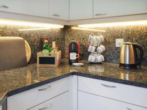 a kitchen with white cabinets and a counter top at Villa Route de la Muraz 9 by Interhome in Villeneuve +22 photos