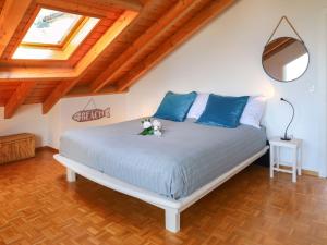 a bedroom with a large bed with blue pillows at Villa Route de la Muraz 9 by Interhome in Villeneuve