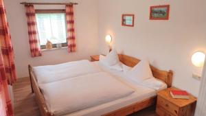 a bedroom with a bed with white sheets and a window at Ferienhof Wolf in Viechtach