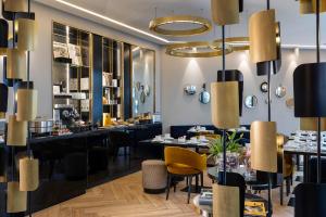a restaurant with tables and chairs and chandeliers at Hotel Le 10 BIS in Paris