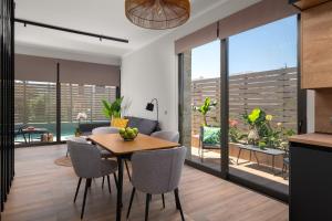 une cuisine et une salle à manger avec une table et des chaises dans l'établissement La Siesta Villas, à Ixia