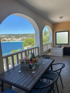 a table with wine glasses and a view of the ocean at Apartman Majba 2 in Zaglavice