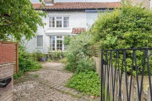 una casa con una recinzione di fronte a un cortile di Angel Cottage, Wenhaston a Halesworth