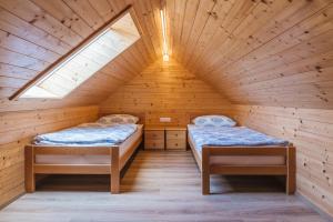 two beds in a cabin with a roof at Pogacar Apartments in Bled