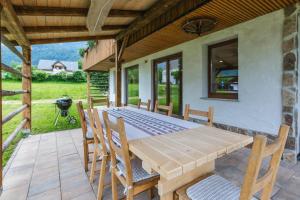 a wooden table and chairs on a patio at Pogacar Apartments in Bled