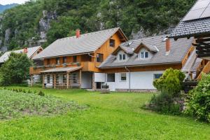 a large wooden house in a field of green grass at Pogacar Apartments in Bled