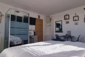 una camera da letto con un grande letto bianco e una scrivania di l'Ecrin de l'Aa - Les Mouettes a Grand-Fort-Philippe