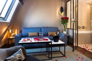 a living room with a blue couch and a table at Hotel Le 10 BIS in Paris