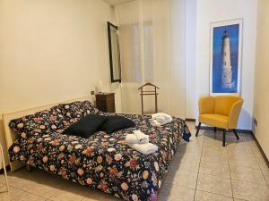 a bedroom with a bed and a yellow chair at Gioiella pool lake pet friendlyBy Case al Lago in Desenzano del Garda