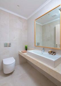 a bathroom with a tub and a toilet and a mirror at Executive Rhodes Villa Villa Akrotiri Stunning Sea Views 3 Bedrooms Lindos in Líndos
