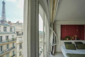 una camera con letto e vista sulla torre Eiffel di Eiffel Tower Vicinity Gem a Parigi