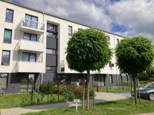 an apartment building with two trees in front of it at Nowoczesne mieszkanie Yellow in Pogórze