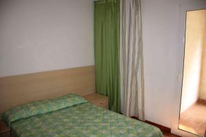 a bedroom with a bed and a green curtain at Sea & sugar in Linguizzetta