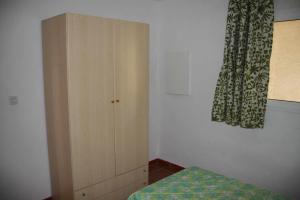 a bedroom with a wooden cabinet and a bed at Sea & sugar in Linguizzetta