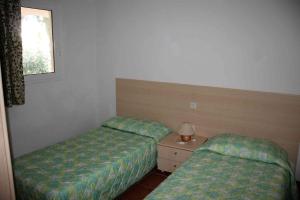 a room with two beds and a lamp and a window at Sea & sugar in Linguizzetta