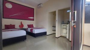 a bedroom with two beds and a painting on the wall at Melaya beach resort 3 in Penginuman