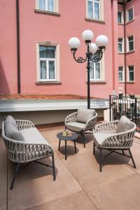 three chairs and a street light next to a building at Hotel Indigo Verona - Grand Hotel Des Arts by IHG in Verona