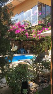 a house with a swimming pool with pink flowers at Relais Amadeus Pousada de Charme in Pirenópolis