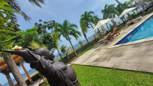 a statue in front of a swimming pool at Melaya beach resort 3 in Penginuman