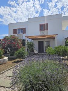 a white house with a garden in front of it at Apartments Cvijet Mora Sreser in Sreser