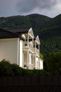 une maison blanche avec une clôture en face d'une montagne dans l'établissement Hotel Magdalener Hof, à Bolzano