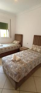 a bedroom with two beds and a window at Nour 2 in Oued Laou