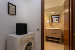 a bathroom with a washing machine and a sink at Rucellai Studio With Shared Pool by Halldis in Milan