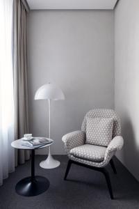 a living room with a chair and a lamp at StandArt Hotel Moscow in Moscow