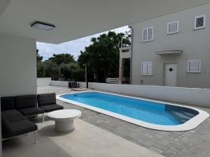 a swimming pool in the backyard of a house at Villa Plesa with office and private pool in Povljana