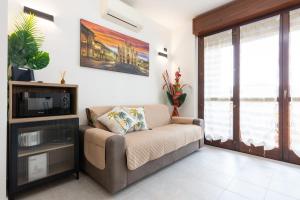 a living room with a couch and a tv at GuestHost - Casa Le Palme in Pioltello