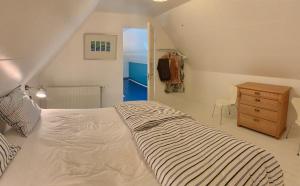 a bedroom with a large white bed and a dresser at Mindedalen - Idyl tæt på alt og helt i fred in Billum