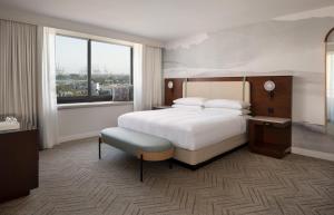 长滩Marriott Long Beach Downtown的一间带床和大窗户的酒店房间