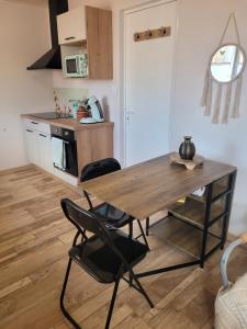 a kitchen with a wooden table and two chairs at La cabanista in Notre-Dame-de-Monts