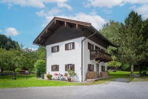 a small white house with a black roof at Ferienwohnungen „Zum Bauern“ in Oberaudorf