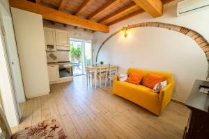a living room with a yellow couch and a table at Appartamenti Procchio Onda e Marina - Tesi Viaggi in Procchio