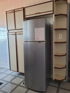 a refrigerator in a kitchen next to a shelf at Apartamento Grande em Itapuã - Vila Velha in Vila Velha