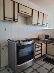 a kitchen with a stove top oven in a kitchen at Apartamento Grande em Itapuã - Vila Velha in Vila Velha