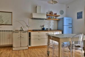 a kitchen with a table and a stove and a refrigerator at La Casa di Livia in Trevignano Romano