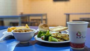 a table with a plate of food and a cup of coffee at Huaxiang Motel - Dachang in Kaohsiung