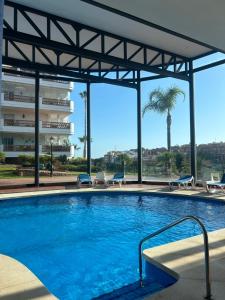 ein großes Schwimmbad mit Stühlen und einem Gebäude in der Unterkunft Mirador at Island Resort in Sitio de Calahonda