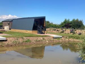 a building with a pond in front of it at Chapel Fields Holiday Park in Chapel Saint Leonards