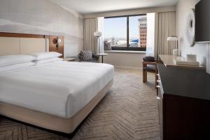 长滩Marriott Long Beach Downtown的配有一张大床和一张书桌的酒店房间
